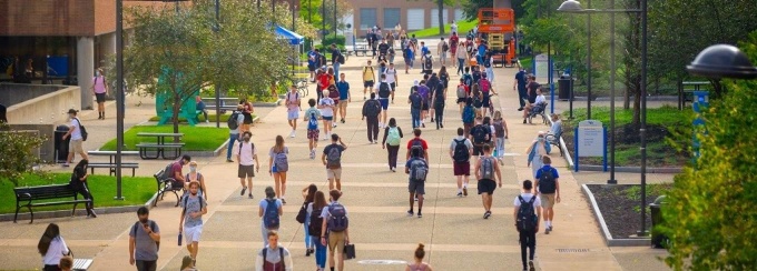 students walking on the academic spine on a warm day. 