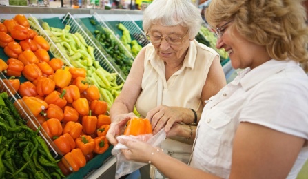 Photo of older adult with younger woman shopping together.