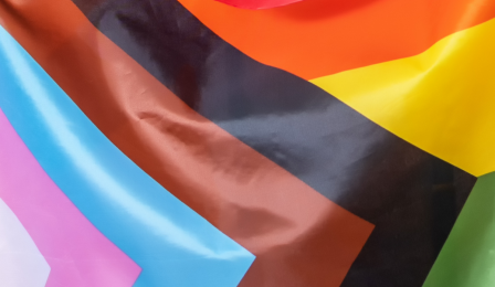 A group of faculty and staff posing on the Progress Pride Paths.