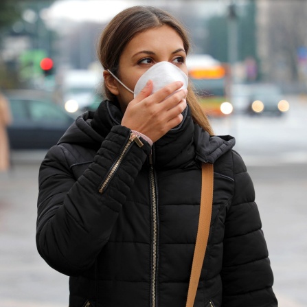 COVID-19 Pandemic Coronavirus Woman in city street wearing protective face mask for spreading of disease virus SARS-CoV-2. Girl with protective mask on face against Coronavirus Disease 2019.