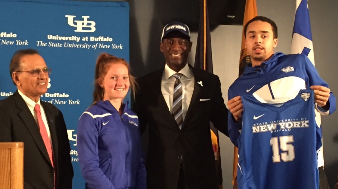 New UB Director of Athletics Allen Greene poses with UB President Satish Tripathi and two student athletes.
