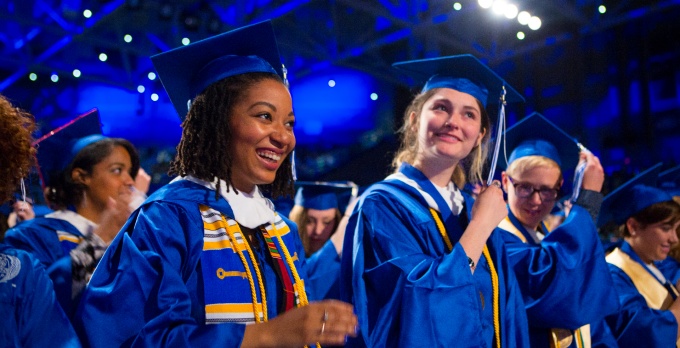 Two UB graduates moving their tassels.