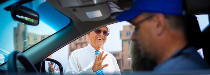 President Tripathi standing by car and greeting families.
