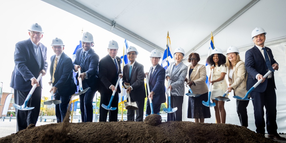 A group of people wearing hard hats and holding shovels pose together at the Russell L. Agrusa Hall Ceremonial Groundbreaking.