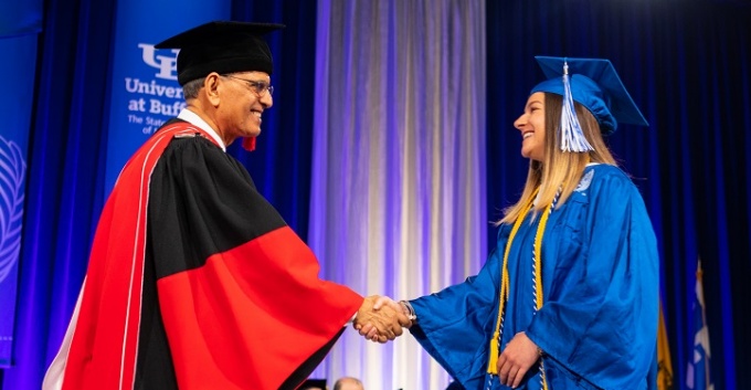 President Tripathi congratulates a graduate at the 2018 College of Arts and Sciences Undergraduate Commencement.