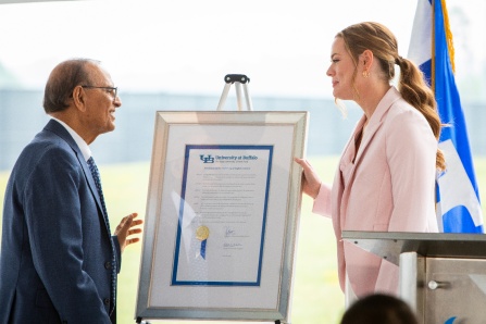 President Satish K. Tripathi presents Brittany Murchie Mulla with the UB Council resolution endorsing the naming of the Brittany Murchie Mulla Sports Performance Center.