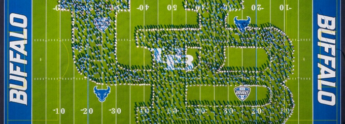 Students standing in a formation to make the UB logo, aerial shot. 