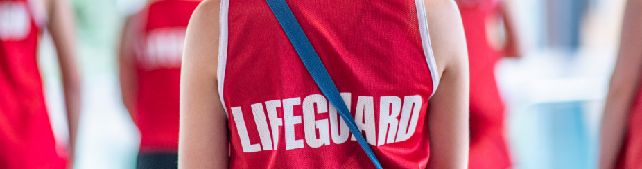 cropped photo of the back of a person wearing a red tank top that reads "LIFEGUARD".