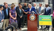 U.S. Senate Majority Leader Charles E. Schumer (at the podium) greets President Satish K. Tripathi at Tuesday's announcement that the Buffalo-Rochester-Syracuse region will receive $40 million for semiconductor manufacturing, research and education.