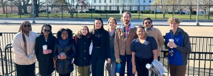 A group of 10 students stand in a line on the barricade just outside of the White House in Washington, D.C. 