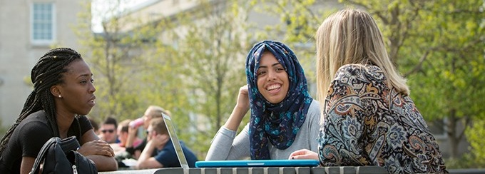 Diverse group of students talking on campus.
