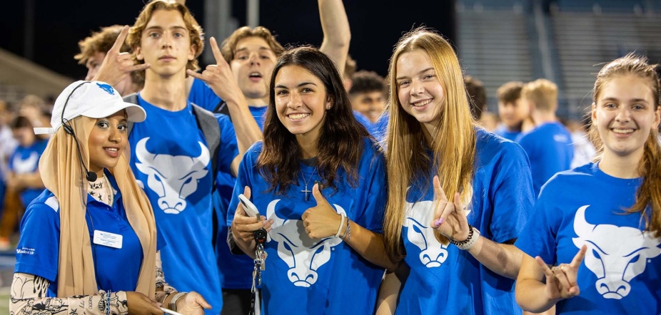 New students making UB horns up hand gesture.