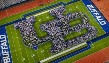 First year students are invited to the New Student Welcome event, hosted by Orientation, Transition and Parent Programs, part of Student Life during Welcome Weekend in August 2023. The event features speakers and concludes with a class photo as students form the Human UB on the football field. Photographer: Douglas Levere. 