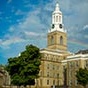 Hayes Hall on UB's South Campus with a blue sky and rainbow behind the building. 