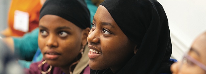 Group of students sitting together and looking towards the left.
