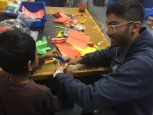 man and child at table making crafts.