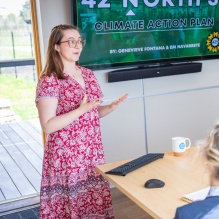 two students giving a presentation in front of a tv screeen.