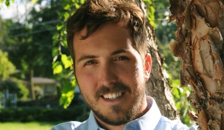 Headshot of a man wearing a lightly colored shirt.