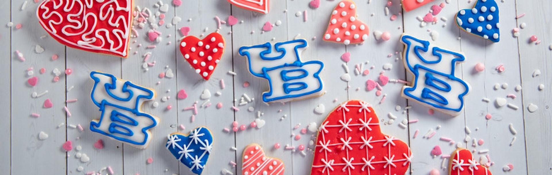 UB cookies displayed among red heart-shaped cookies. 