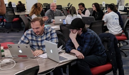 Various teams ponder their solutions at the area's first UB Blockchain Buildathon.