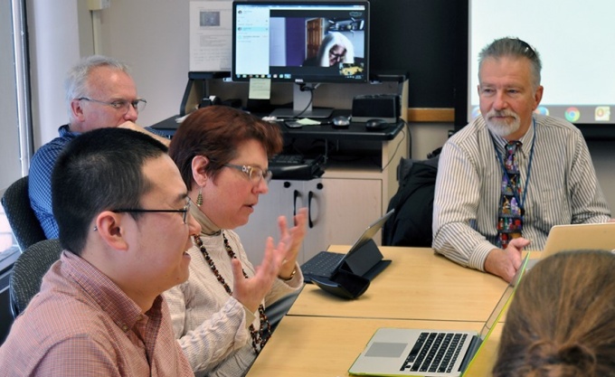 UB professor Dr. Valerie Nesset leads a group of Faculty IT Liaisons in a conference room on the 5th floor of Baldy Hall.