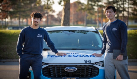 Tech Squad students with Tech Squad car, going to an appointment in a residence hall.