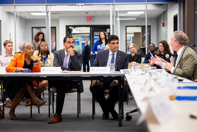 SUNY Trustee Eunice Lewin, SUNY Chancellor John B. King Jr. and Venu Govindaraju, vice president for research and economic development, sit at a table while listening to a speaker at the roundtable discussion. 