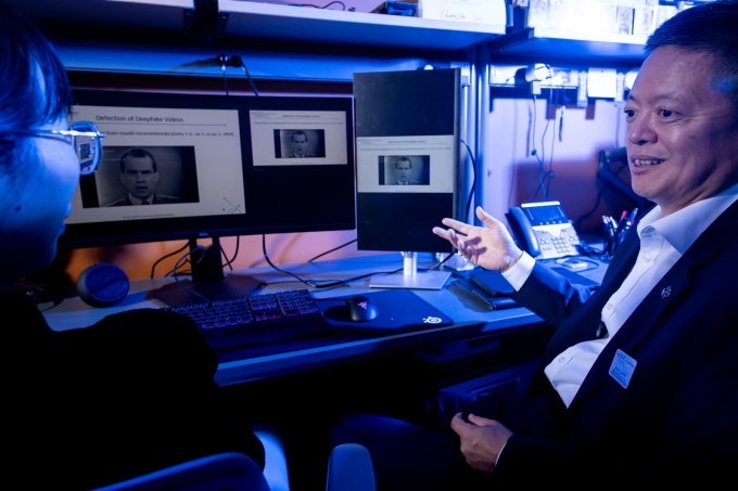 Siwei Lyu seated at a large computer monitor. 