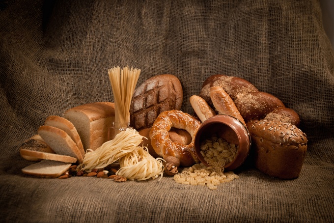 Various kinds of breads piled onto a table. 