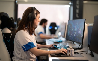 Zoom image: Student gaming on a computer in the esports lounge.