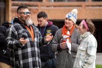 Aaron Maracle outside wearing sunglasses and talking to a few people. 