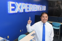 Trung Nguyen pointing to a sign that says Experience UB.