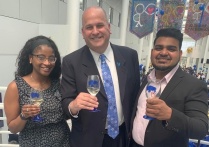 Brian Hamluk with two people, all holding glasses to toast.