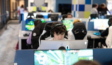 Students sitting and playing video games in the esports lounge.