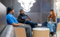 Peter Johnson sitting and talking with two people.