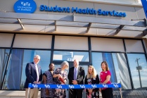 The UB community gathers for the grand opening of the Student Health Services center, located at 4350 Maple Road, near Sweet Home Road, in August 2022. Cutting the ribbon from left, Provost A. Scott Weber; Sharon Mitchell, senior director of student wellness; Susan Snyder, director, Student Health Services; Brian Hamluk, vice president for student life; Mary Stock, clinical assistant professor and senior physician; and Paula Taton, clinic manager. Photographer: Meredith Forrest Kulwicki.