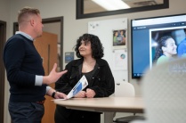 Grace Osaba standing and talking to someone at a conference table.