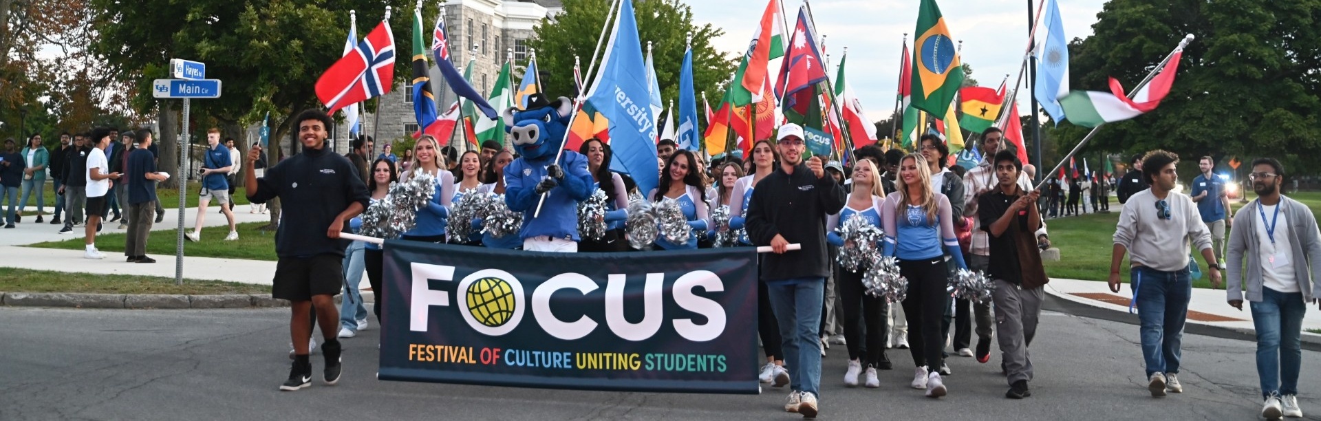 Students carrying international flags during FOCUS parade on South Campus. 