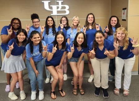 UB women in science and engineering student ambassadors pose with the UB horns up hand gesture. 